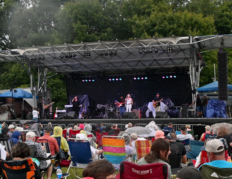 A photo depicting musicians on an outdoor stage.